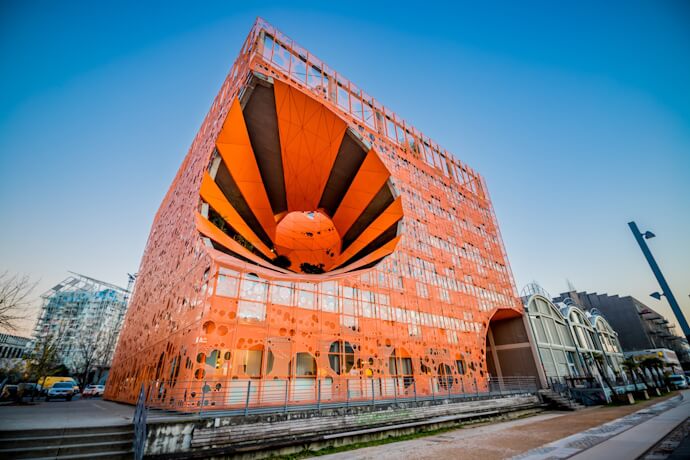 Modern orange architecture of Lyon’s Confluence district with its striking geometric façade.