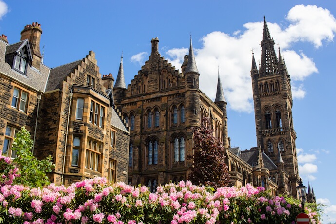 University of Glasgow’s Gothic revival buildings in Scotland, framed by colorful flowers