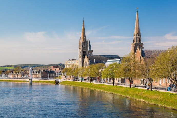 Riverside view of Inverness in the Scottish Highlands, featuring church spires along the River Ness