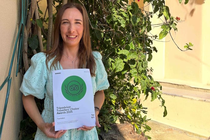 The TourTailors Commercial and Customer Experience Director smiling and holding the 2025 TripAdvisor Travellers’ Choice Award.