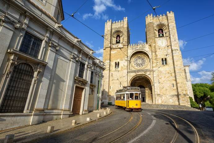 Old tram in front of cathedral in Lisbon