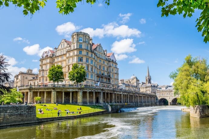  People enjoying a sunny day in Bath with view of the Pulteney Bridge