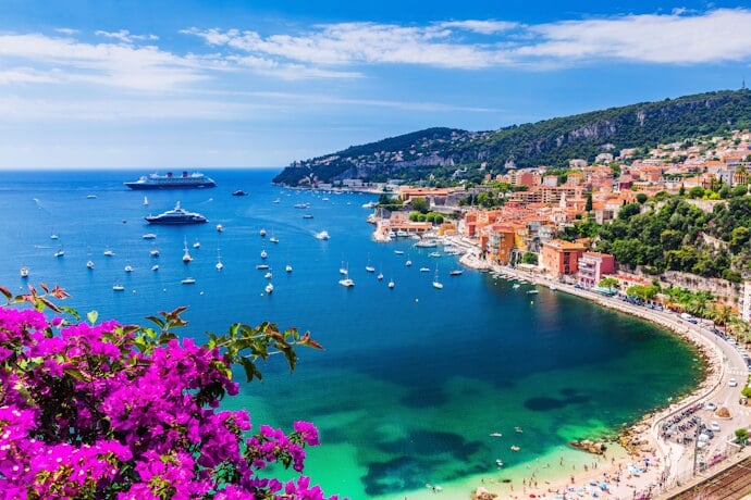 Scenic bay with boats and vibrant coastal village in Southern France