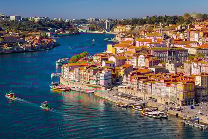 A panoramic view of Porto’s historic riverfront, with traditional boats and hillside neighborhoods